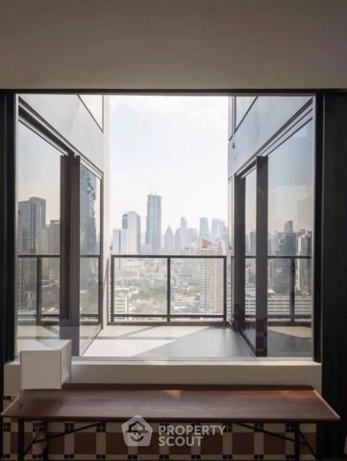 Stunning cityscape view from modern high-rise balcony with sleek glass railing.