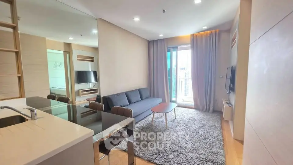 Modern living room with open kitchen and city view balcony in a stylish apartment.