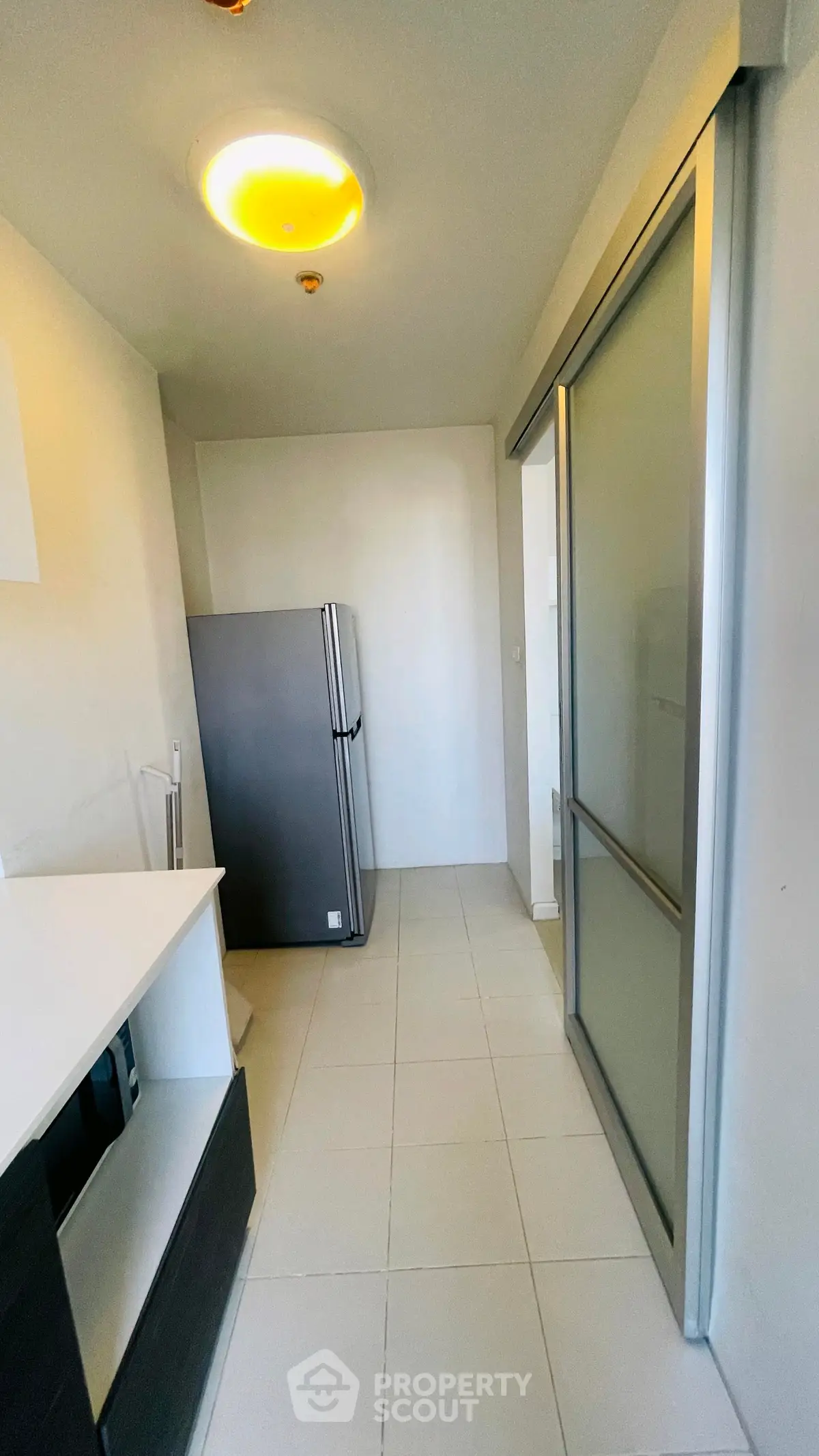 Modern kitchen with sleek design and stainless steel fridge in a compact layout.