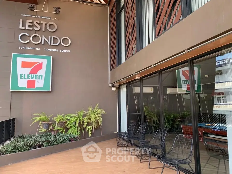 Modern condo entrance with seating area and convenience store sign.