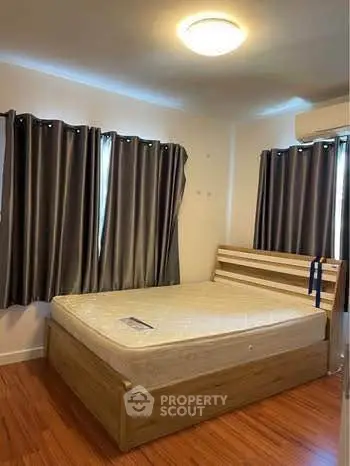 Cozy bedroom with wooden flooring and modern furnishings, perfect for a restful retreat.
