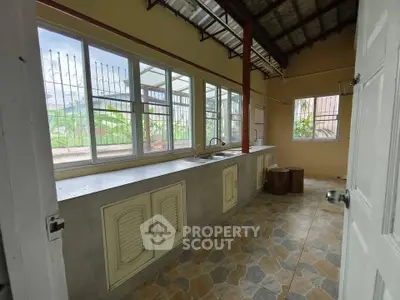 Spacious kitchen with large windows and open layout, perfect for natural light and ventilation.
