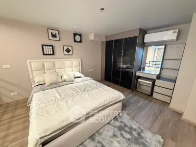 Modern bedroom with stylish decor and ample storage in a cozy apartment.