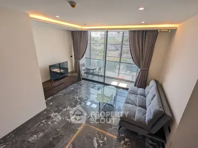 Modern living room with marble flooring and large windows offering natural light.