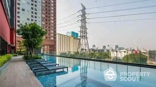 Luxurious rooftop pool with city skyline view in modern residential complex.