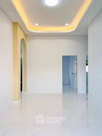 Modern minimalist interior with elegant ceiling lighting and arched doorway.