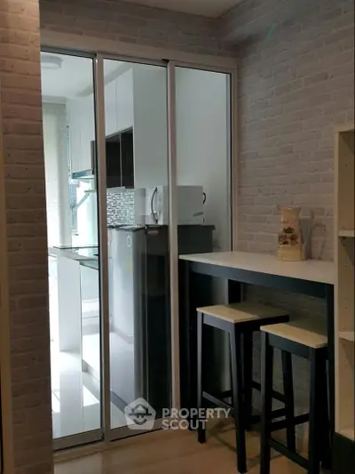 Modern kitchen with sliding glass doors and breakfast bar in a stylish apartment.