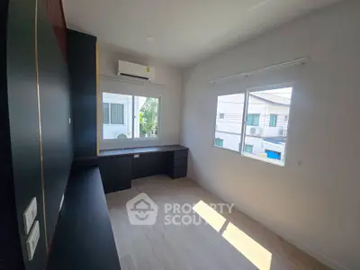 Spacious study room with large window and built-in desk, perfect for productivity and natural light.