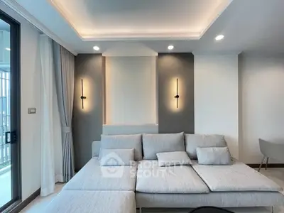 Modern living room with stylish gray sofa and elegant lighting, perfect for relaxation and entertaining.
