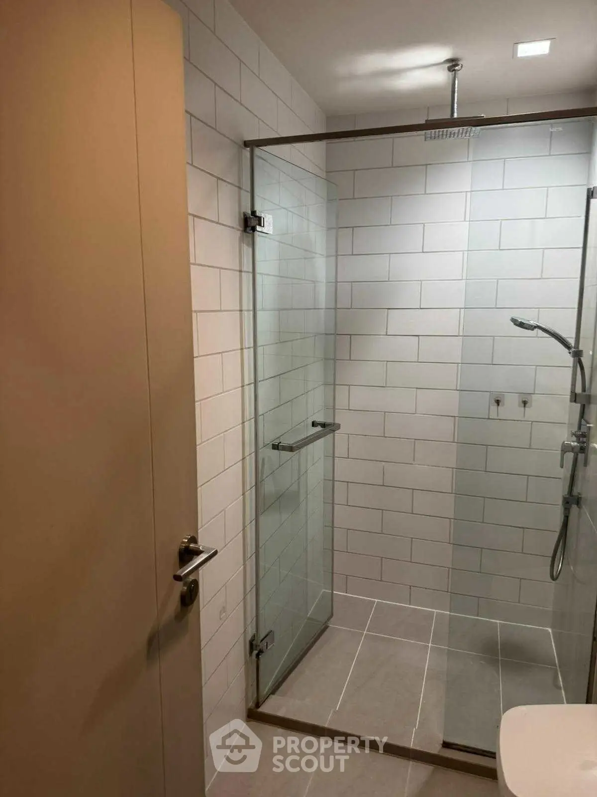 Modern bathroom with glass shower enclosure and sleek tile design.