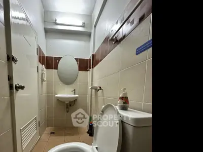Compact bathroom with modern fixtures and neutral tile design.