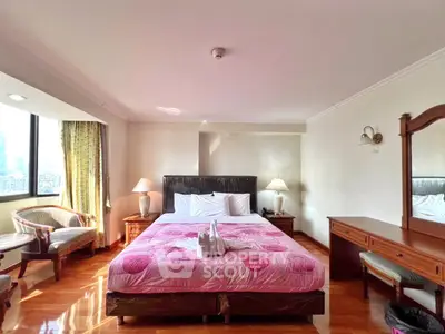 Spacious bedroom with city view, elegant furnishings, and natural light.