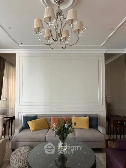 Elegant living room with plush sofa, stylish chandelier, and cozy decor accents.