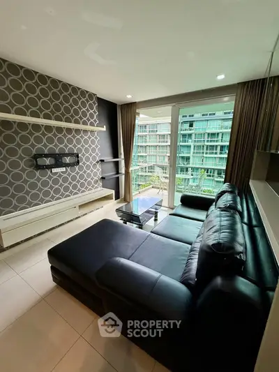 Modern living room with stylish decor and large window overlooking lush greenery.