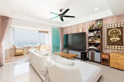 Luxurious living room with ocean view and modern decor, featuring a spacious balcony and stylish furnishings.