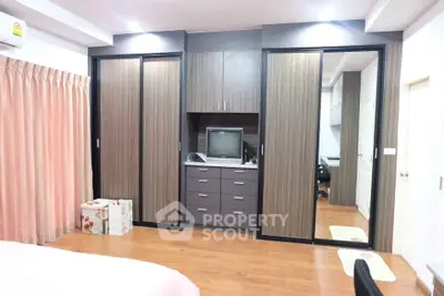 Spacious bedroom with modern built-in wardrobe and wooden flooring