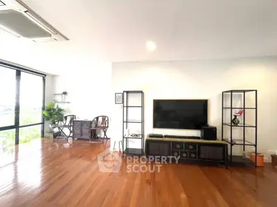 Spacious living room with hardwood floors and modern entertainment center