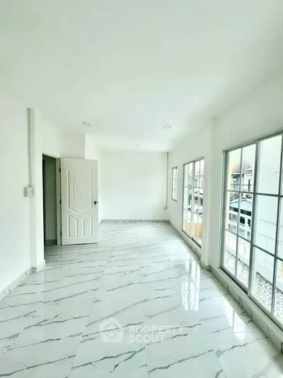 Spacious bright room with marble flooring and large windows in modern home