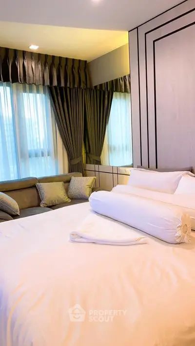 Luxurious bedroom with elegant curtains and plush bedding in modern apartment.