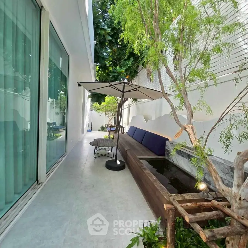 Charming outdoor patio with modern seating and lush greenery, perfect for relaxation and entertaining.