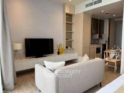 Modern living room with sleek furniture and open kitchen layout, perfect for urban living.