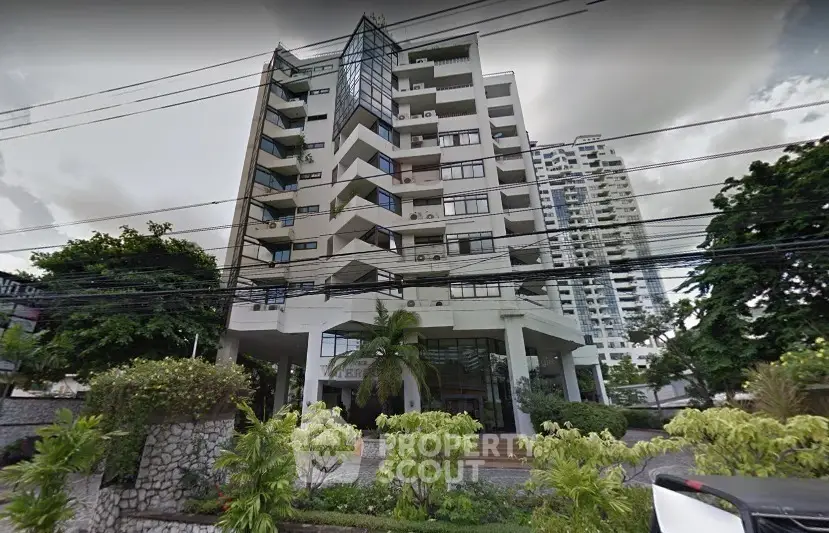 Modern high-rise building with lush greenery and unique architectural design.