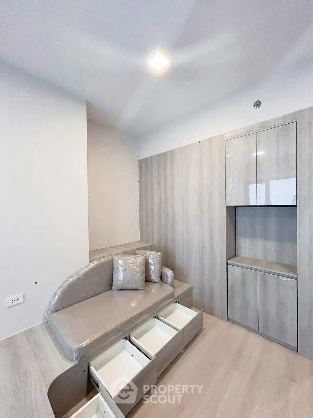 Modern minimalist living room with built-in storage and sleek furniture design.