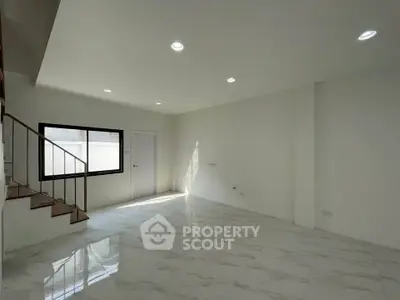 Spacious modern living room with elegant staircase and natural light