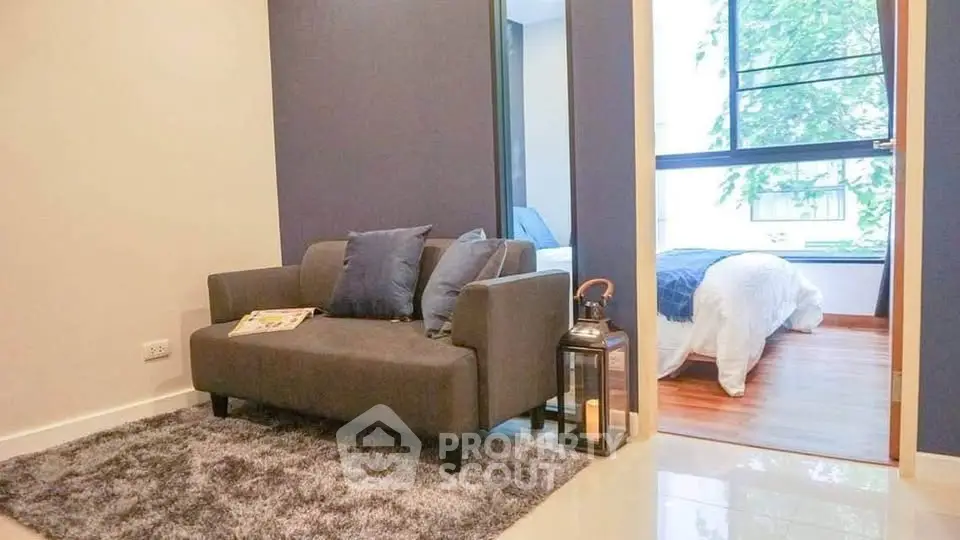 Modern living room with cozy sofa and view into a stylish bedroom