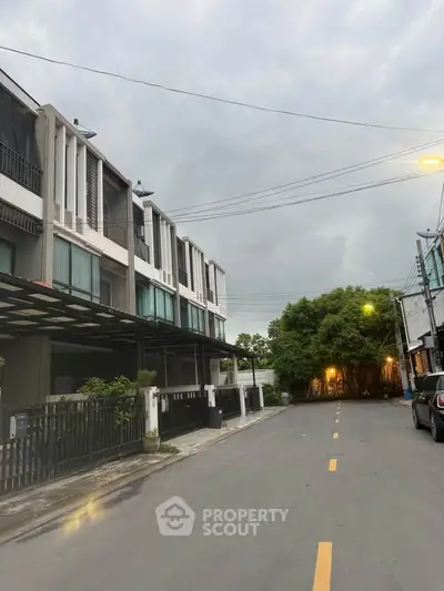 Modern townhouse exterior with sleek design on a quiet street, perfect for urban living.