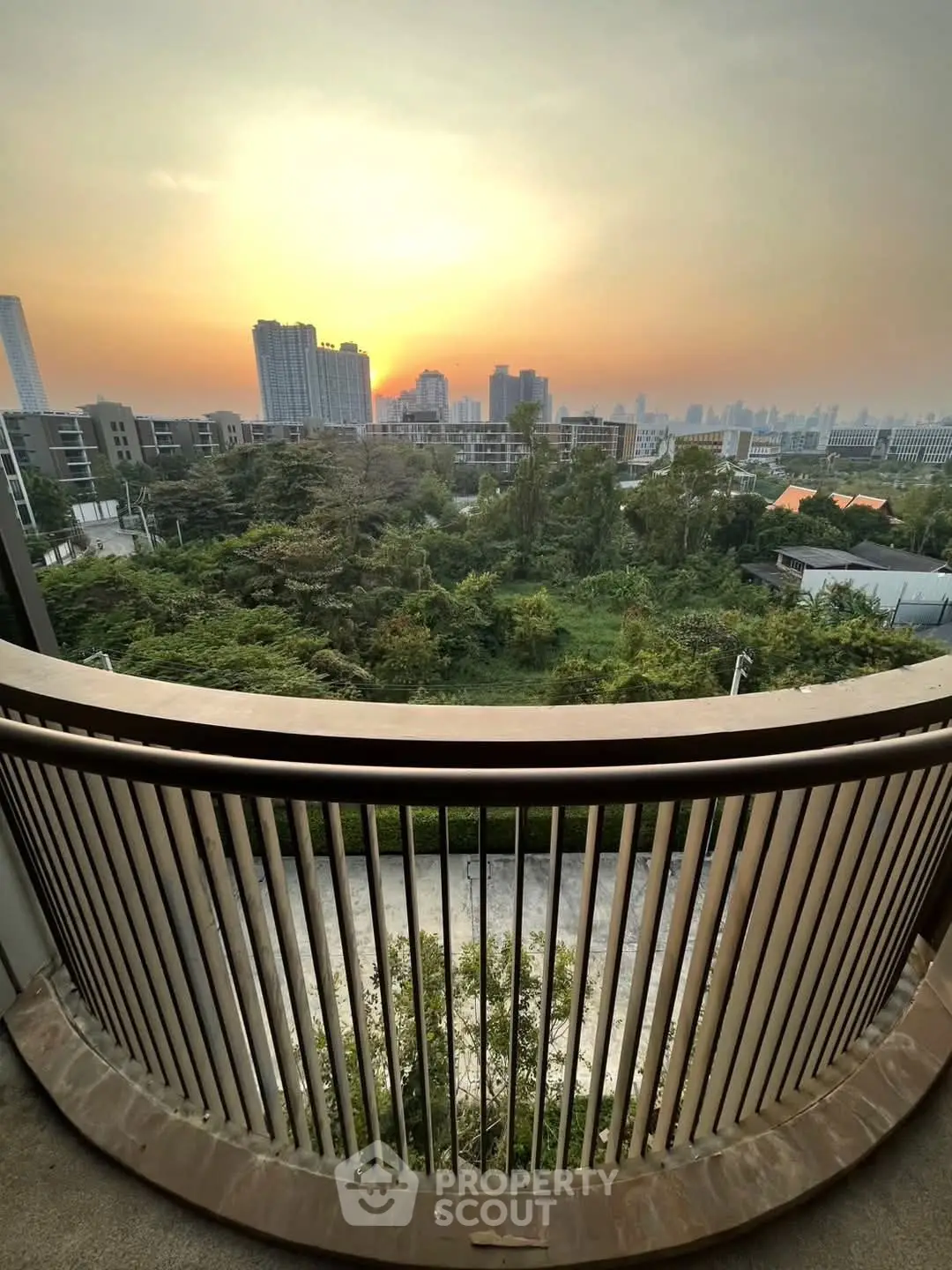 Stunning cityscape view from a high-rise balcony at sunset