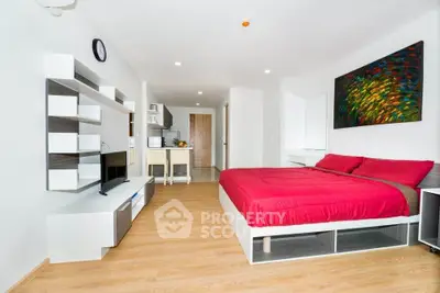 Modern studio apartment with stylish decor and open layout, featuring a cozy bed and sleek entertainment unit.
