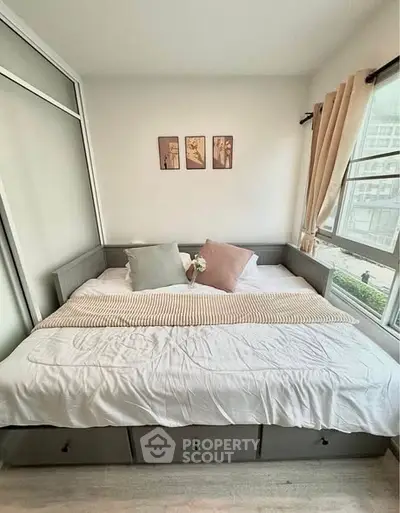 Cozy bedroom with large window and stylish decor in modern apartment.