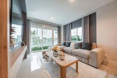 Modern living room with large windows and cozy seating area in a stylish home.