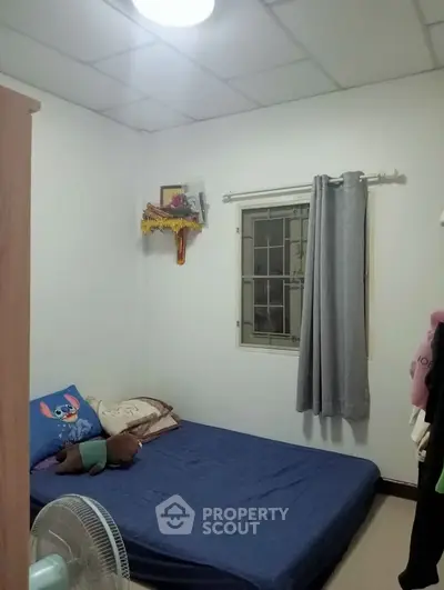 Cozy bedroom with simple decor and natural light, ideal for restful nights.