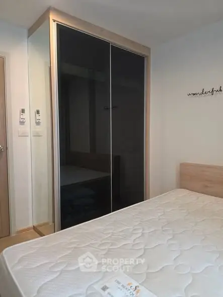 Modern bedroom with sleek wardrobe and comfortable mattress in stylish apartment.