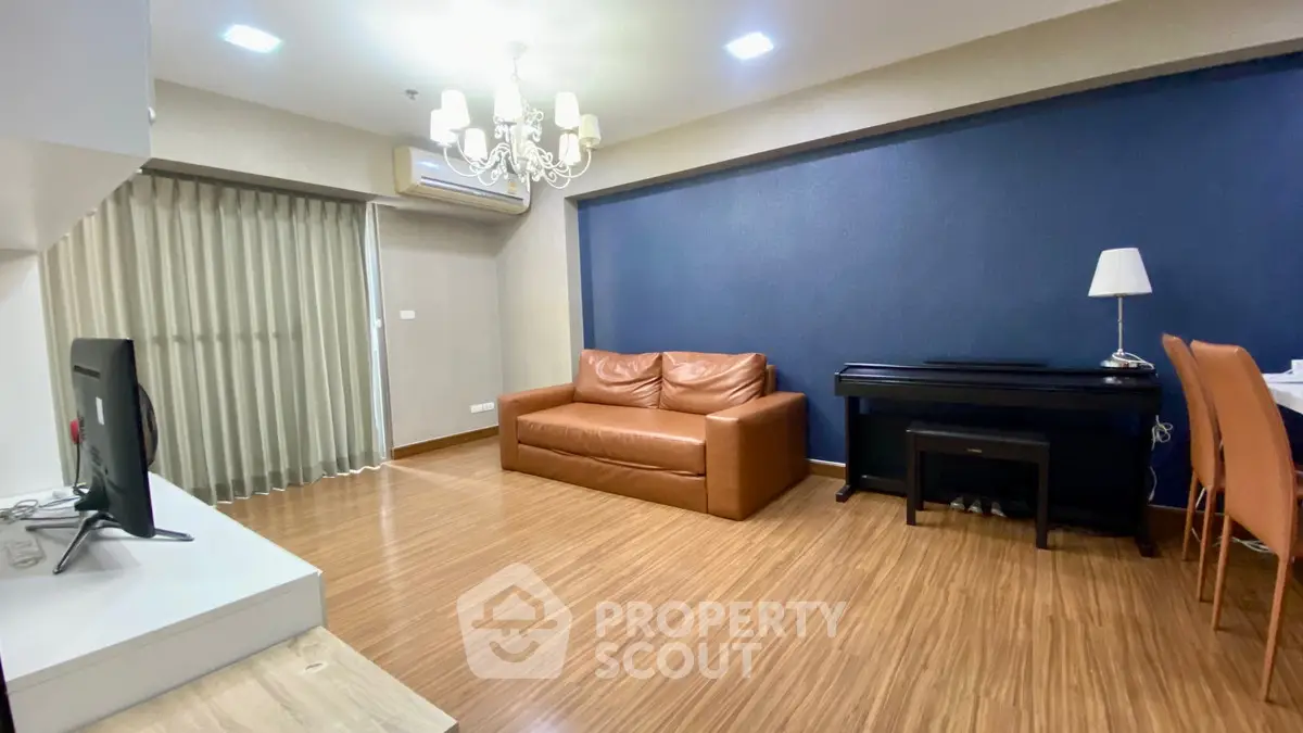 Spacious living room with elegant chandelier and modern furnishings