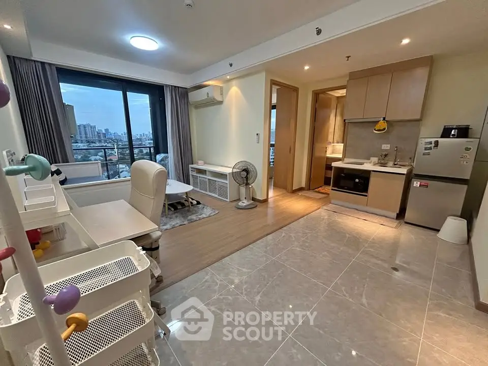 Modern open-plan living room with kitchen and city view balcony in a stylish apartment.