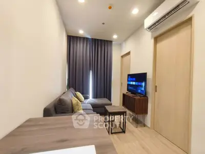 Modern living room with cozy sofa, TV, and air conditioning in a stylish apartment.