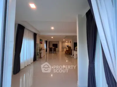 Spacious modern living room with elegant curtains and glossy tile flooring