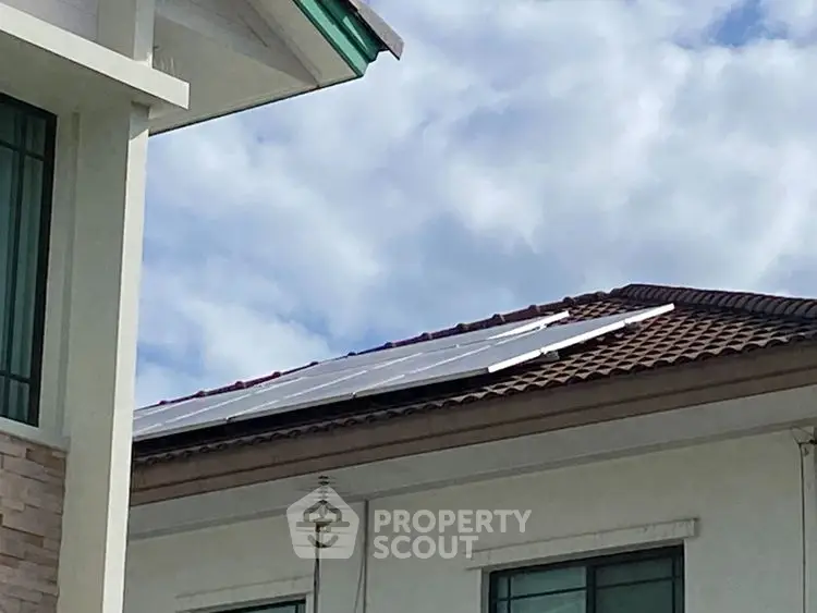 Modern house with solar panels on roof under blue sky