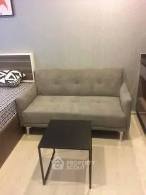 Cozy living room with modern gray sofa and sleek black coffee table.