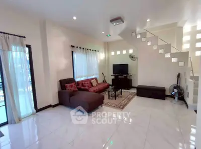 Spacious modern living room with sleek tile flooring and stylish staircase