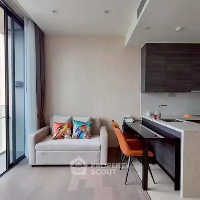 Modern living room with cozy sofa and stylish kitchen area in open layout apartment.