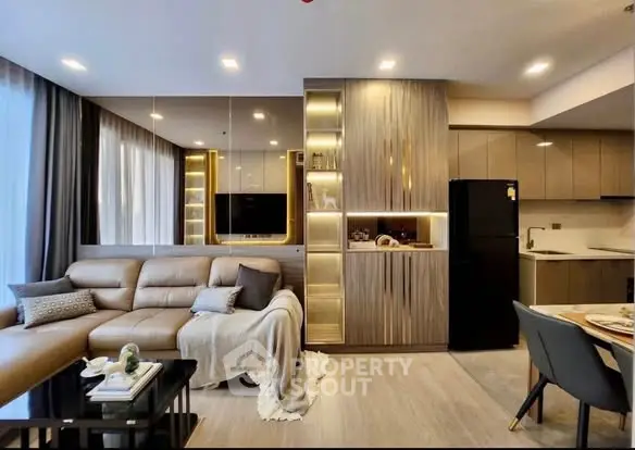 Modern living room with open kitchen, stylish decor, and cozy seating area in a contemporary apartment.