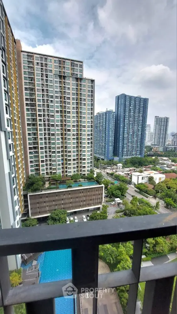 Stunning high-rise apartment view with pool and lush greenery in urban setting.