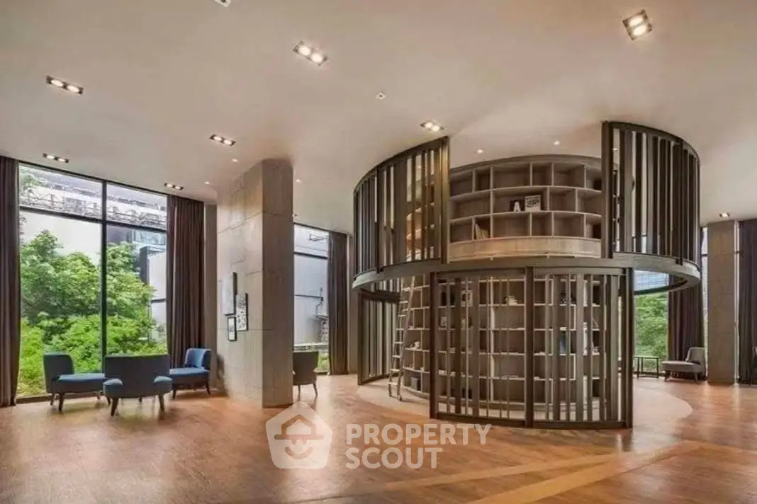 Luxurious modern library with floor-to-ceiling windows and circular bookshelf in upscale building.