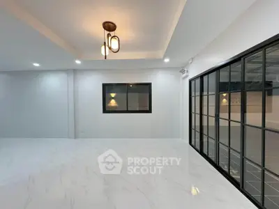 Spacious modern living room with elegant lighting and large windows.