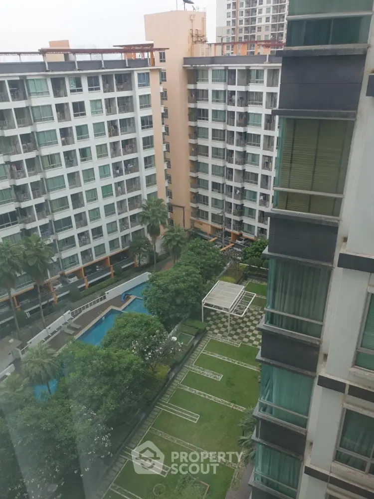 Stunning high-rise apartment view with lush garden and pool area