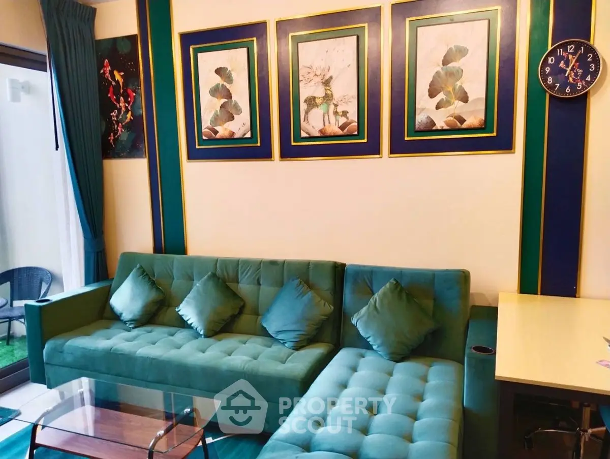 Stylish living room with green sofa and elegant wall art